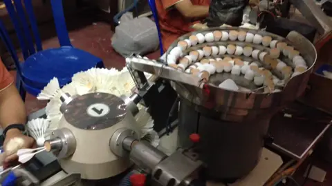 Assembling the skirt of a badminton shuttlecock.