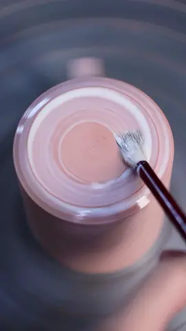 Waxing the bases of some mugs prior to glazing and firing. This layer prevents glaze from absorbing onto the bottom when they’re dipped, which ultimately means less time spent tidying them up afterwards. #satisfyingvideo #brushwork #pottery #wax #waxing