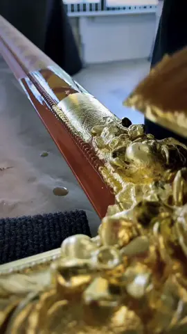 applying gold leaves to a picture frame