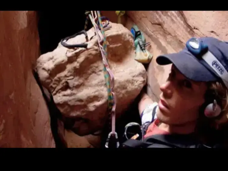 El hombre se salva amputándose el brazo con una cuchilla de 2 pulgadas.  Aron Ralston estaba explorando Bluejohn Canyon solo el 26 de abril de 2003, cuando cayó una roca que colgaba mientras bajaba por el cañón ranurado.  De repente, su brazo derecho se alojó entre una roca de 800 libras y la pared de un cañón. Ralston también quedó atrapado a 100 pies debajo de la superficie del desierto ya 20 millas de la carretera.  Trató continuamente de liberar su brazo durante cinco días, bebiendo lentamente la poca agua que le quedaba y comiendo los dos burritos que componían su magra dieta.  No le había dicho a nadie sobre sus planes para escalar. Dos burritos, algunas migas de barra de chocolate y una botella de agua era todo lo que tenía. Se quedó sin agua y se vio obligado a beber su propia orina.  Aron Ralston aceptó su destino, angustiado y delirante. Grabó su nombre, fecha de nacimiento, fecha de muerte presunta y las letras RIP en la pared del cañón con sus toscas herramientas. Después de eso, intentó quedarse dormido mientras filmaba las despedidas de su familia.   Ralston tuvo un sueño esa noche en el que jugaba con un niño con solo la mitad de su brazo derecho mientras entraba y salía de la conciencia. Cuando despertó, creyó que el sueño significaba que sobreviviría y formaría una familia. Se dedicó a la supervivencia con mayor determinación que nunca.  Aron Ralston tuvo una epifanía después de soñar con tener una familia: no necesitaba cortarse los huesos. En cambio, podría romperlos.  Pudo romper los huesos aplicando el torque de su brazo atrapado. Hizo un torniquete con su botella de agua y detuvo todo el flujo de sangre. Después de eso, pudo cortar su músculo y piel con un cuchillo barato y desafilado de dos pulgadas y sus tendones con alicates. Dejó sus arterias para el final, sabiendo que después de cortarlas no tendría mucho tiempo. Todo el proceso tomó una hora, durante la cual Ralston perdió el 25 por ciento de su sangre. Con mucha adrenalina, Ralston salió del cañón de tragamonedas.  Cuatro horas después de cortarse el brazo, los rescatistas lo salvaron después de escalar por 6 millas. #parati #paratii #españa #latina #fyp #fypシ #xyzbca 