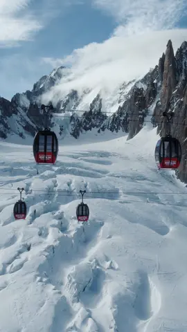 Gondolas dangling high in the air surrounded by the giant mountains of the Mont Blanc range. This gondola spans miles over glacier and can take you from the French to the Italian side of Mont Blanc #chamonix #france #italy #mountains #winter #snow #skiing #ski #alps #skilift #gondola #montblanc #travel #drone #aerialcinematography 