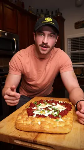 Shakshuka focaccia 🤯 and it’s vegetarian! My roommates and I ate this entire thing immediately after the camera cut off… For the focaccia recipe, follow @ethanchlebowski recipe on YouTube! *NOTE: bake it in parchment paper lined baking dish! This is for easy removal once pieces of the middle have been removed.  Make sure the parchment extends up the sides of the dish. Shakshuka Ingredients: -1/2 medium yellow onion, diced -1/2 bell pepper, diced -2 cloves garlic, minced -3 tbsp harissa paste -2 tsp smoked paprika -1 tsp cumin -1 tsp chili powder -1 can crushed tomatoes -salt -3 eggs -6 oz crumbled feta -cilantro, rough chopped -make shakshuka while the focaccia is baking -in a med-high skilled add the peppers and onions w a splash of olive oil.  Sauté 2 mins. -add garlic and sauté 1 min -add harissa paste and stir -add dry smoked paprika, cumin, and chili powder & stir, toasting the spices for ~1 min. -add crushed tomatoes and stir.  Bring to a light simmer for about 15 minutes.  Stir occasionally  -add splashes of water if it gets too thick -add salt to taste -once the focaccia is finished, while still in the parchment lined baking dish, cut a hole in the top in the shape of an 7” diameter circle.  -using tongs, remove the bead inside the circle, keeping the focaccia in tact on the bottom. -if you begin to see holes in the bottom, take the pieces that have been removed, flip them over, and cover the holes. -add the finished tomato sauce to the center hole and spread evenly. -using the back side of a ladle, create 3 divots in the sauce. -add one egg to each hole. -place back into 425 deg oven for 15-20 minutes.  Remove once whites have completely set -take out and let cool for 20 minutes -holding the parchment paper, remove the focaccia from the baking dish, then slide the parchment paper out from underneath. -top with crumbled feta and cilantro #f#focaccias#shakshukav#vegetarianf#foodrecipef#foodb#breadt#tomatosaucef#fetacheesetomatoes 