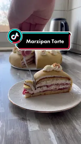 Einfache Marzipan Torte 😋🙌 26cm Durchmesser  Boden: 4 Eier  100g Zucker  2 TL Vanillepaste  125g Mehl  1 TL Backpulver  Füllung: 750ml Sahne  70g Zucker  2-3 TL Vanillepaste  2 Pck Sahnesteif  80g gemahlene Haselnüsse  300g Himbeerkonfitüre  Etwas Haselnuss Krokant  400g Marzipan zum überziehen  Zubereitung: 1. Boden: Eier trennen, Eiweiß mit Zucker und Vanillepaste gut aufschlagen. 2. Eigelb nach und nach unterrühren. 3. Mehl und Backpulver und je Masse sieben und vorsichtig von Hand unterheben. 4. Die Masse in eine 26cm Form füllen. 5. Bei 180C, O|U-Hitze ca.20min backen. 6. Boden auskühlen lassen und zwei mal durchschneiden. 7. Füllung: Sahne, Zucker, Vanillepaste und sahnesteif steif schlagen. 8. Einen kleinen Teil zur Seite legen für die Deko. 9. Und die andere Sahne gemahlene Haselnüsse unterheben. 10. Auf den untersten Boden die Hälfte der Marmelade streichen, darauf etwas Sahne streichen, etwas Krokant verteilen und das wiederholt ihr dann noch einmal. 11. Den letzten Boden drauf legen und die Torte dünn mit Sahne einstreichen. 12. Den Marzipan mit Puderzucker dünn ausrollen und über die Torte legen. 13. Mit der Sahne die ihr zur Seite gelegt habt und mit etwas Krokant die Torte dekorieren.  #marzipan #marzipantorte #backideen #foodtiktok #FoodLover #rezeptideen #kuchenrezepte 