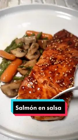 Salmón en salsa de soja, miel y limón 🍋🍯 El salmón es uno de los pescados que más triunfan. Su precio está bastante desorbitado, pero merece la pena darse un capricho de vez en cuando. Hoy os traigo un recetón de salmón en salsa de soja, miel y mostaza; una combinación de sabores que le van como anillo al dedo. ¡Espero que lo probéis! 📌 No olvides guardar el video para no perderlo y etiquetar a un amigo/a cheeselover. 📝 INGREDIENTES: ▪️500g lomo de salmón  ▪️Sal y pimienta al gusto ▪️Aceite de oliva ▪️Hortalizas/verduras para guarnición   🔸Salsa de miel, soja y limón: ▪️2 cucharadas soperas de miel ▪️2 cucharadas soperas de salsa de soja ▪️1 cucharada sopera de zumo de limón  ▪️1 cucharadita de sésamo  ▪️1 diente de ajo 👨🏻‍🍳 ELABORACIÓN: 1️⃣ Limpiar los lomos de salmón, quitar la piel, racionar y salpimentar.  2️⃣ Dorar el salmón en sartén o plancha con un chorrito de aceite de oliva (comenzando por el lado donde estaba la piel), unos dos minutos por lado. Podemos dejarlo hasta 3 minutos si nos gusta bien hecho. 3️⃣ Juntamos todos los ingredientes de la salsa  y mezclamos bien hasta integrar. Reducimos en sartén hasta que tenga la textura deseada: cremosa y ligera, textura de salsa, para entendernos. Retiramos del fuego y reincorporamos el salmón. Napamos con la salsa y servimos. 4️⃣ Acompañamos con la guarnición que prefiramos, en este caso verduritas salteadas. ¡A disfrutar! . . #salmonalaplancha #salmón #recetarapida #cocinatiktok #cocinatradicional #salsadesoja 
