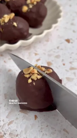 Protein snickers bliss balls 🤍 need a sweet treat to prep for the week? These are sosossoo easy, dangerously good 😮‍💨👌 •1/2 cup peanut butter •3/4 cup packed, pitted dates (soaked in hot water for 15-20 min) •1/3 cup peanuts •1/4 cup your fave protein powder (can sub 2-3 tbsp oat flour) •1 tsp vanilla + pinch of sea salt  •1 1/3 cups chocolate chips Note: you can taste the mixture & if your dates didn’t make it sweet enough, you can add a tbsp or two of coconut sugar, monk fruit, etc. if you use maple syrup you may need to add an extra tbsp of flour or protein if they’re too wet to roll into balls! :)  After soaking the dates and hot water, add them to a food processor with the peanut butter, vanilla, & sea salt. Process for a minute or so, until the peanut butter and dates are blended together, and most of the dates have been broken down into a paste. Careful not to over process as the mixture can get a little oily. Then add the protein powder and process again until combined. Then I did the peanuts and pulse a few times, until they’re slightly broken down and distributed.  Roll the mixture into balls and place on a lined cookie sheet. Melt the chocolate until smooth, dip each ball, and return to the cookie sheet. Top with crushed peanuts if you want. Place in the freezer for at least two hours to allow them to firm up. Store in the freezer in an airtight container! 🤍 #snickers #proteinball #blissballs #highprotein #healthydessert #glutenfreedessert #proteinpowder #healthysnacks #refinedsugarfree #nobakedessert