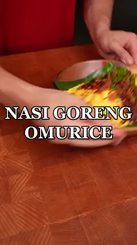 🇮🇩🇯🇵Nasi goreng Omurice I’ve been requested to do this recipe multiple times so here’s my twist on Nasi Goreng but in the style of a Japanese Omurice! Much love to our Indonesian friends ❤️ INGREDIENTS: Nasi Goreng: - 2 cups day old rice   - day old rice - 1-2 tbsp Sambal Terasi - 1 smoked duck breast, cubed - 6 garlic cloves, sliced - 5 shallots, sliced - 1/4 cup edamame (soy beans) - 1 pack shimeji mushrooms - 2 tbsp Kecap Manis - salt and pepper to taste Sambal topping sauce: - 1/4 cup dried chili - 5 Shallots  - 6 cloves Garlic - 5 Tomatoes  - 1 inch Belacan - 2 tbsp palm sugar - 1 tbsp tomato paste (for color, optional) - vegetable oil for frying Omelette: - 4 eggs Garnish: - Spring onions - Crispy fried onions INSTRUCTIONS: - Saute smoked duck until slightly crispy and fat is rendered. Add in your vegetables and cook through for around 3-4 mins. Add in your sambal and day old rice. Cook through until rice is soft again and season with kecap manis (sweet soy sauce). Set aside. - To make your sambal topping sauce, blend/process together ingredients listed under “sambal”. Fry in about 3 tbsp of oil on low heat for around 20-30mins. Season with palm sugar/salt to taste. Set aside. - To make the omellette I don’t really have any particular set of instructions since it’s mostly by feel. Although I can give a few tips: 1. I used a 20cm non stick shallow frying pan. You don’t want the edges of the pan to be too high so you can flip it easily. 2.  Use high heat at first to form the curds in the egg. Vigorously stir eggs with chopsticks and move the pan back and forth. 3. When egg is about 50% done tilt the pan forward so all of the egg runs down to the edge of the pan. This will help build the shape and help the egg fold over itself. 4. Turn the heat down to low THEN you start folding the edges to make the omelette shape. 5.  Tap handle while simultaneously flicking the pan gently upwards. If the egg wont fold by itself you can use a spatula to flip it. 6. Watch plenty of videos of japanese people making omurice 😂 You’re bound to learn from the experts. - Plate rice using a football shaped mold, top with your egg, sambal, crispy onions, spring onions, serve and enjoy!❤️ #indonesianfood #nasigoreng 