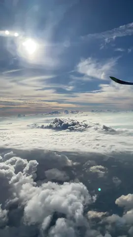 Beautiful view of clouds and sun from plane window with blue sky 🌌 full of clouds. #plane #planewindow #clouds #planevideos #aviation #travelvideos #wanderlust #bluesky #fullofclouds #sunny #city #sky 