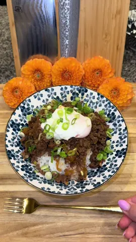 Gyūdon🇯🇵🥩 (Japanese Beef Rice Bowl) #Recipe #EasyRecipe #EasyRecipes #gyudon #japan #japanesefood  In a pan on medium-high heat (with oil) add: -1 large yellow onion (cut into half moons) -2 tablespoons of chopped ginger  -1 tablespoon of minced garlic  -1 cup of water  -1 cup of Mirin -1/2 cup of soy sauce -1/4 cup of light brown sugar Cover and let this cook for about 4 to 5 minutes then add 2 pounds of shaved ribeye (or pretty much any thinly shaved beef that you would use to make a Philly Cheesesteak. But ribeye is definitely the best!) Let this cook (it shouldn’t take any more than 2 minutes) and then turn off the heat and let it stew for about 5 more minutes. Also, give it a taste and add more soy sauce if you want.  Then add white rice to a bowl, top it off with the beef and some of the sauce, and an egg.  In Japan, they serve this with an Onsen Egg (which is cooked low and slow.) I used a poached egg today but you could also use a soft boiled or a fried egg if you want. Then finish it off with some green onion.  Enjoy💜