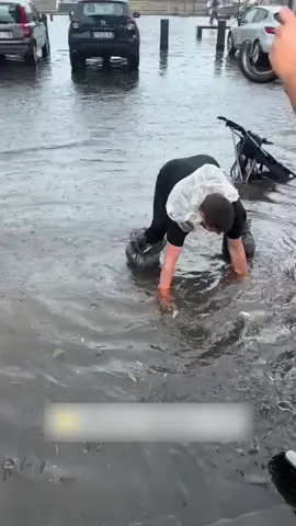 A Good Samaritan is seen helping unclog a drain after a flood 