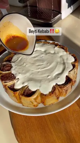 Beyti Kebabı çok sonradan deneyip müdavimi olduğum bir lezzet🤤🤌daha önce denemeyenler bu yöntemle pratik ve lezzetli bir beyti kebabı yapabilirsiniz🤌  Malzemeler 750 gr dana kıyma (çift çekim) 1 adet orta boy soğan  Yarım çay bardağı galete unu  1 tatlı kaşığı domates salçası  1 tatlı kaşığı kimyon 1 tatlı kaşığı toz biber  1 tatlı kaşığı tuz  1 çay kaşığı karabiber  (Tüm malzemeyi iyice yoğur dolapta bir iki saat dinlendir) 5 adet patlıcan (Patlıcanı uzun düz seçmeye çalışalım.) Patlıcanı alacalı soyup ince keselim.tuzlu suda yarım saat bekletip suyunu süzüp kurutalım. Kızgın yağda arkalı önlü kızartalım. Kızaran patlıcanları kağıt havlu üzerine alıp fazla yağını alalım. Yufkayı açıp her tarafına zeytinyağı sürelim. Videodaki gibi katlayıp patlıcanları dizelim. İki üç parmak kalınlığında rulo şekli verdiğimiz köfteyi hamurunu patlıcanların üzerine yerleştirip sıkı saralım. İki parmak genişliğinde keselim.eşit boyda olmasına dikkat edelim. Fırın kabına ya da benim gibi kelepçeli kalıba dizip üzerine zeytinyağı gezdirelim. 170 derece fırında kızarana kadar pişirelim. Üzerine 1 su bardağı süzme yoğurda 2 diş sarımsak ve tuzu karıştırıp dökelim. 1 yemek kaşığı tereyağına 1 çay kaşığı toz biber 1 çay kaşığı pul biber ve yarım çay kaşığı nane kızartıp yoğurdun üzerine dökelim. Sıcak servis edelim  @hemsirenin_blogu 🤌🤌 #beytikebap #kebap