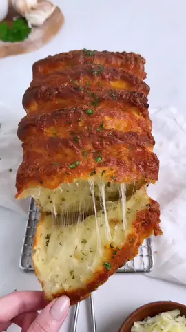 Cheesy Pull-Apart Garlic Bread 🧄🧀 Fluffy milk bread layered with cheese and roasted garlic herb butter. Crispy on the outside and soft on the inside. 🫶 Full recipe is linked in my profile.  #baketok #baking #bread #recipes #halloweenbaking #fyp #pullapartbread #garlicbread #cheesebread 