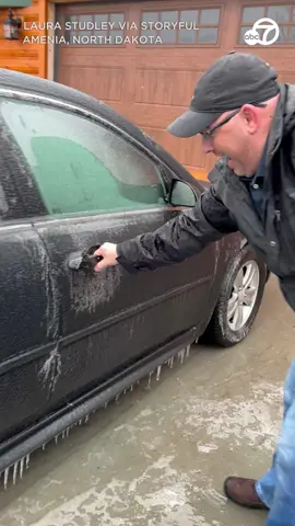 FROZEN SHUT! A man struggled to open a frozen car door after an ice storm hit parts of North Dakota. 🥶❄️