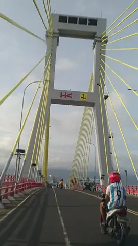 Jembatan Soekarno  Setelah sempat mangkrak selama 12 tahun, akhirnya jembatan Soekarno di jalan Boulevard 2, Kota Manado ini sudah mulai dapat digunakan. Jembatan gantung yang mencapai panjang mencapai 1.127 meter ini menjadi ikon kota Manado. Jembatan yang terletak di atas Sungai Tondano dan Pelabuhan Manado ini mengalami hambatan karena dana dan perbedaan kontur tanah di area teluk Manado. Dari atas jembatan kita dapat melihat Pulau Bunaken dan Gunung Manado Tua di tengah Teluk Manado.  Di sisi seberang ada perkampungan warna-warni sama seperti konsep perkampungan Jodipan di Malang. Jembatan ini merupakan bagian dari Manado Outer Ring Road yang menghubungkan Boulevard 1, Boulevard 2, dan By Pass Manado. #travel #travelog #tiktok #jalanjalan 