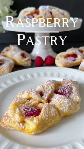 Click here for the Recipe 🤍 Raspberry Pastry  Indulge in the delightful combination of flaky puff pastry, velvety Custard, and juicy raspberries with these scrumptious Raspberry Custard Pastries. 📝 Ingredients: - 1 sheet of puff pastry - Fresh or frozen raspberries - 250 ml milk - 20 g cornstarch - 2 egg yolks - 50 g sugar - 1 teaspoon vanilla extract - 1 teaspoon butter 🤍 Instructions: 1. Preheat the oven to 190 degrees Celsius. 2. In a saucepan, mix milk, cornstarch, egg yolks, sugar, and vanilla extract. Heat over medium heat, stirring constantly, until the mixture thickens. 3. Remove the custard from the heat, stir in the butter, and let it cool. 4. Roll out the puff pastry and cut it into eight equal rectangles. 5. Place a portion of custard in the center of each rectangle and top with some raspberries. 6. Fold the pastry over the filling, connecting the corners. 7. Whisk one egg yolk with a tablespoon of milk and brush it over the top of the pastries before baking. 8. Place the pastries on a baking sheet lined with parchment paper. 9. Bake in the preheated oven for approximately 15-20 minutes or until golden brown. 10. Allow the pastries to cool briefly before serving and dust with powdered sugar. Enjoy these delicious Raspberry Custard Pastries with a cup of tea or coffee! 🤍