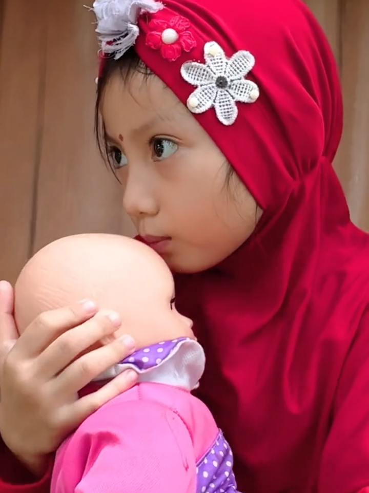 Aqila bermain mengasuh boneka bayi