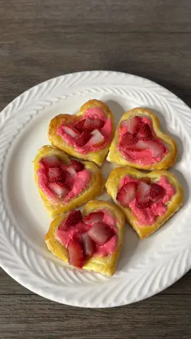 Strawberry Cream Cheese Heart Danish 💕 One word DELISH! So perfect for valentines! The recipe is below:  1. For the filling combine 4oz cream cheese, 2 tbsp white sugar, 1/2 tsp vanilla extract and a few drops of red food coloring. Mix together until light and fluffy, set aside. 2. Unfold 1 sheet puff pastry. Use a heart shaped cookie cutter. Score each heart about 1/4 from the edge, being careful to not cut all the way through the pastry. 3. Spread your cream cheese mixture inside the border. 4. Dice strawberries small and spread evenly.  5. To make an egg wash, use 1 egg and mix in 1 tbsp water. Mix together and then brush in the outer edges. 6. Bake for 15 minutes at 400 degrees, let sit for 5 minutes and then enjoy warm! 💓Follow for more inspo! • • • #danish #dessertrecipe #valentinesdessert #easyrecipee #easydessert #spring #hellofebruary