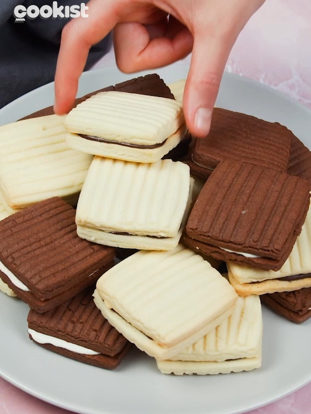 These stuffed #cookies are so delicious, you won't be able to stop at one! 🤤 Here's what you need to make them: 👉INGREDIENTS 135g (½ cup) of  butter, softened 140ml (½ cup + 1 tbsp) of vegetable oil 1 egg 60g (½ cup) of powdered sugar a pinch of vanilla powder 60g (½ cup) of cornstarch 260g (2 cups) of all-purpose flour 20g (2 tbsp) of cocoa powder Dark and white chocolate melted 👉METHOD 1. Preheat the oven to 180C/350F. 2. Whisk butter with vegetable oil, eggs, vanilla, and powdered sugar in a medium bowl. 3. Add flour and cornstarch, and mix well until smooth pastry forms. Take half of the pastry and mix cocoa in. 4. Roll each half in between parchment paper. Make strips on the surface using a fork. Cut into squares. 5. Bake cookies for 12 minutes. Let cool down. 6. Make a cookie sandwich with two cookies and melted chocolate in between. What would you serve them with? 😍 #cookistwow #cookistrecipe #recipes #easy #quick #fun #delicious #cooking #baking #tasty #homemade #foodie #foodlover #foodblog #yummy #foodtok