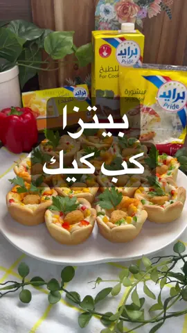 بيتزا كب كيك كريمية وتذوب بالفم من لذاذتها  استخدمت جبنة تشيدر برايد اللي احبها واحلى موزريلا من برايد ماشاءالله مطتها رهيييبة الطريفة للعجينة : كوبين دقيق+ ملعقتين كبار سكر + م/وسط خميرة ملعقة كبيرة حليب بودرة + نص م/ص ملح  ربع كوب زبدة برايد ذايبة+ ٣/٤ كوب ماء دافي واعجن جيداً واتركها تخمر 45 دقيقة وافردها واقطعها نفس طريقة الفيديو واحطها بصينية الكب كيك لصوص البيتزا: في الخلاط كوب وربع جبن تشيدر برايد مبشور + ثلث كوب كريمة برايد + حبة فلفل رومي احمر  واخلط واوزعها على العجينة  وارش عليها جبن موزريلا من برايد  ودجاج بوب كورن شويته بالقلاية الهوائية وحطيت ذرة وفلفل الوان راحت عالفرن مدة ٣٥ دقيقة اتحمرت من تحت وبعدين اتحمرت من فوق وقدمتها بالعافيه @Pride Cheese Arabia 