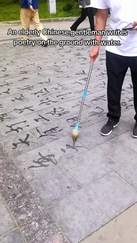 An elderly Chinese gentleman writes poetry on the ground with water. #ChineseCalligraphy #ChineseCulture The characters previously written evaporate and disappear.