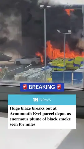 A huge fire has broken out at a parcel depot run by courier firm Evri in Avonmouth, Bristol, with the smoke visible for miles. Avon Fire and Rescue has urged locals to keep their windows and doors shut as thick plumes of smoke poured into the sky. The parcel depot is located at the Access 18 industrial estate around seven miles from Bristol city centre.  Images shared on social media showed the flames licking at the rear of a car as stacks of parcels were consumed by the bonfire. #fire #evri #warehouse #news #uknews #breakingnews 