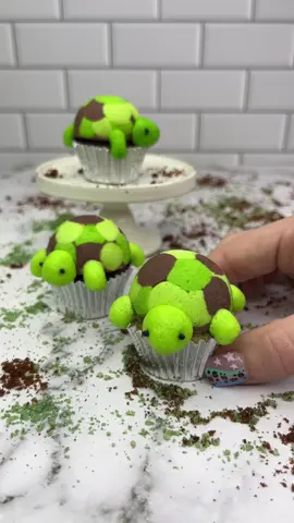 Time to Turtle 🐢 🐢 🐢 Buttercream turtle shells 💚  I made these with my silicone cake pop mold 💚 Use two shades of green and chocolate buttercream to add dots into your silicone mold FREEZE 🥶 for 15 minutes Add chocolate buttercream into the mold, followed by your mini cupcakes FREEZE 🥶 again for 20 minutes. Push them out of the mold 🐢  I then added legs, a tail and a head and small black sprinkles for the eyes. ✨ VOILA #cupcakes #turtle #minicake #cakedbyrach #cakeart #cupcakedecorating #cutefood #cupcakeartist #caketok 