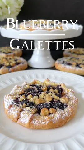 Blueberry Galettes Recipe 🤍 Indulge in the delightful flavors of summer with our Blueberry Galettes recipe! 🥰 Ingredients: For the crust: - 200 g all-purpose flour - 100 g cold butter, diced - 1 tbsp sugar - A pinch of salt - 3-4 tbsp cold water For the filling: - Approx. 200 g fresh blueberries For the crumble topping: - 40 g all-purpose flour - 25 g rolled oats - 25 g sugar - 30 g cold butter, diced For the pudding layer: - 200 ml milk - 40 g sugar - 20 g cornstarch - 2 egg yolks - 1 tsp vanilla extract 🤍   Instructions: 1. Preheat the oven to 200°C (390°F) and line a baking sheet with parchment paper. 2. For the crust: In a bowl, combine the flour, cold butter, sugar, and salt. Use your fingers or a pastry cutter to mix until the mixture resembles coarse crumbs. Gradually add the cold water and knead until a dough forms. Shape the dough into a ball, wrap it in plastic wrap, and chill in the refrigerator for at least 30 minutes. 3. For the filling: Wash the blueberries and set aside. 4. For the crumble topping: In a bowl, mix together the flour, rolled oats, sugar, and cold butter until crumbly. Chill in the refrigerator. 5. For the pudding layer: In a small saucepan, whisk together the milk, sugar, cornstarch, egg yolks, and vanilla extract. Cook over medium heat, stirring constantly, until the mixture thickens. Remove from heat and let cool. 6. Roll out the dough on a floured surface and cut into 6 equal-sized circles (about 12cm in diameter). Place the dough circles on the prepared baking sheet. 7. Spread a thin layer of the pudding mixture onto the center of each dough circle, leaving a border of about 1.5 cm. 8. Evenly distribute the blueberries over the pudding layer. 9. Fold the edges of the galettes over the filling, forming a rustic shape. 10. Sprinkle the crumble topping evenly over the blueberry filling. 11. Bake the galettes in the preheated oven for 20-25 minutes, or until golden brown. 12. Remove from the oven and allow to cool slightly before serving. Dust with powdered sugar, if desired. Enjoy these delicious Blueberry Galettes with their crispy crumble topping and creamy pudding layer! 🤍