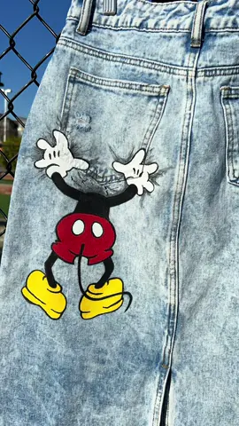 Add a magical touch to your style with this hand-painted Mickey Mouse denim skirt! 🐭✨ With its playful design, Mickey seems to pop out of the wall and straight into your look! 😍 Ready to add a touch of Disney to your closet? ✨ #DisneyFashion #UniqueStyle #MickeyMouse Dale un toque mágico a tu estilo con esta falda en jean pintada a mano de Mickey Mouse! 🐭✨ Con su divertido diseño, Mickey parece salir de la pared y ¡directo a tu look! 😍 ¿Lista para añadir un toque de Disney a tu armario? ✨ #ModaDisney #EstiloÚnico #mickeymouse 