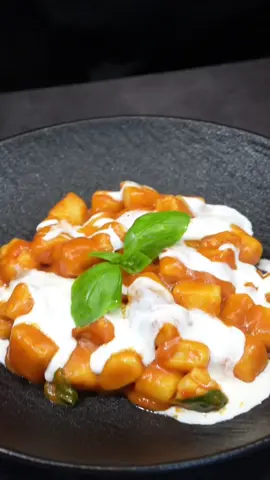 Ingredients For the Gnocchi: 500 g (about 1.1 lbs or 4 medium) potatoes 100 g (about 3/4 cup) flour 1 egg yolk Salt, to taste Grated nutmeg, to taste For the Cherry Tomato Sauce: 500 g (about 1.1 lbs) cherry tomatoes 2 cloves garlic Fresh basil, to taste Salt and pepper, to taste Extra virgin olive oil, to taste For the Shrimp: 5 large shrimp, cleaned Extra virgin olive oil, to taste Salt, to taste For the Final Seasoning: Fresh basil leaves Burrata, to taste Instructions Gnocchi Preparation: Bake the potatoes at 350°F (180°C) for 45 minutes without a layer of salt, allowing them to dry well. Once cooked, mash the potatoes and mix with the egg yolk, flour, a pinch of salt, and grated nutmeg until you have a smooth dough. Form the gnocchi and set aside. Cherry Tomato Sauce Preparation: Wash the cherry tomatoes and season with basil, salt, pepper, and a drizzle of olive oil. Roast in the oven at 350°F (180°C) for about 30 minutes. Once cooled, blend with the garlic and strain through a sieve to obtain a smooth cream. Shrimp Head Cream Preparation: Blend the shrimp heads with a drizzle of olive oil and a pinch of salt. Strain the obtained cream through a sieve. Cooking and Finishing: Dice the shrimp meat. Boil the gnocchi in salted water until they float to the surface. In a skillet, sauté the gnocchi with the tomato sauce and a tablespoon of shrimp head cream. Add the shrimp pieces and toss with olive oil and fresh basil leaves. Serve hot, topping each dish with a quenelle of fresh burrata. Enjoy your cooking! @GialloZafferano 