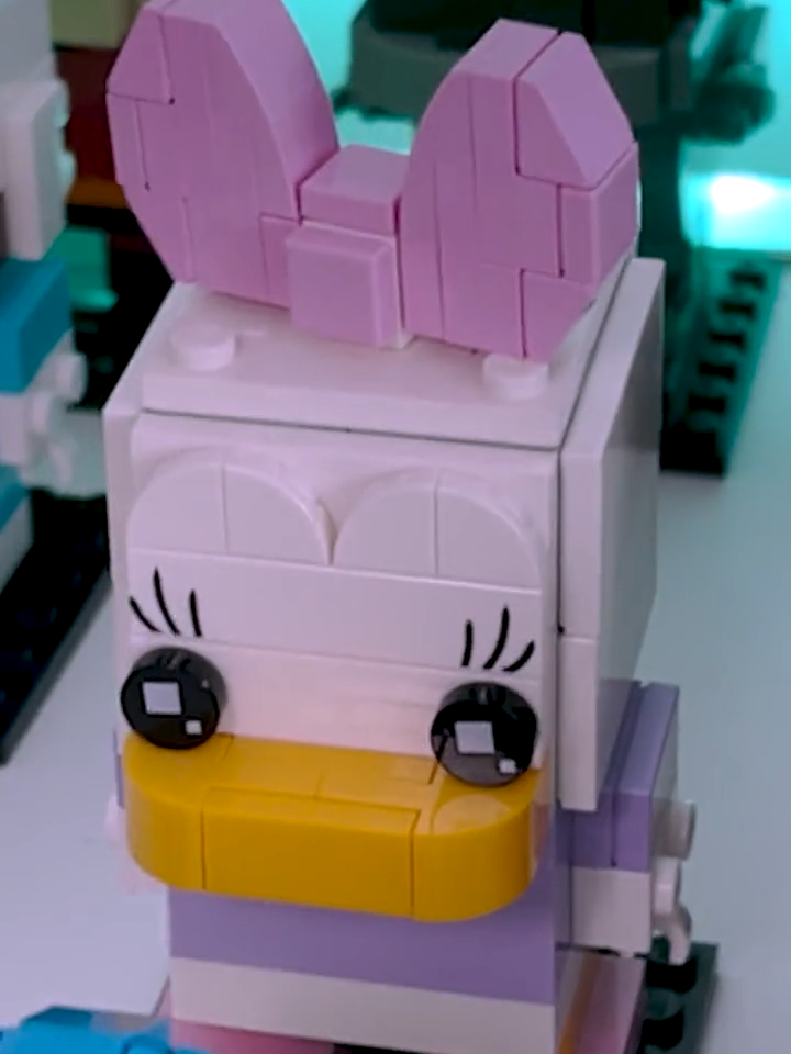 LEGO® BrickHeadz Daisy Duck 40476 Embark on a mesmerizing click-clack journey to Daisy's adventures with this speed build of the LEGO BrickHeadz Daisy Duck. Let the rhythmic sounds of LEGO pieces guide you as you create this adorable Daisy Duck figure, set to the cheerful beats of Toploader - Dancing in the Moonlight. Experience the tranquility of creation and the joy of bringing this charming character to life as Daisy Duck takes shape before your eyes, piece by piece.