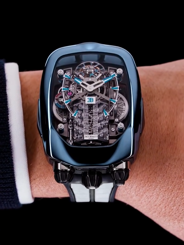 x Bugatti Chiron Tourbillon - Blue Titanium. The case is a glass and metal volume whose structural elements echo the Chiron's unique design in the signature horseshoe Bugatti grille, the quarter glass, the muscular bodywork, and the haunting headlights. #Jacobandco #Inspiredbytheimpossible #Bugatti #Chiron