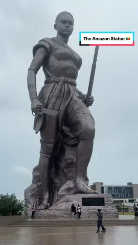 At the Amazon statue Cotonou, Benin Republic. The Amazon Statue in Cotonou, Benin Republic is a popular tourist attraction.  It is a 98 feet tall statue of Queen Tassi Hangbe, who established the Dahomey Amazons, an all-female military unit that operated from the 1700s till 1904.  #amazon #beninrepublic🇧🇯 #travel #tourism #fyp 