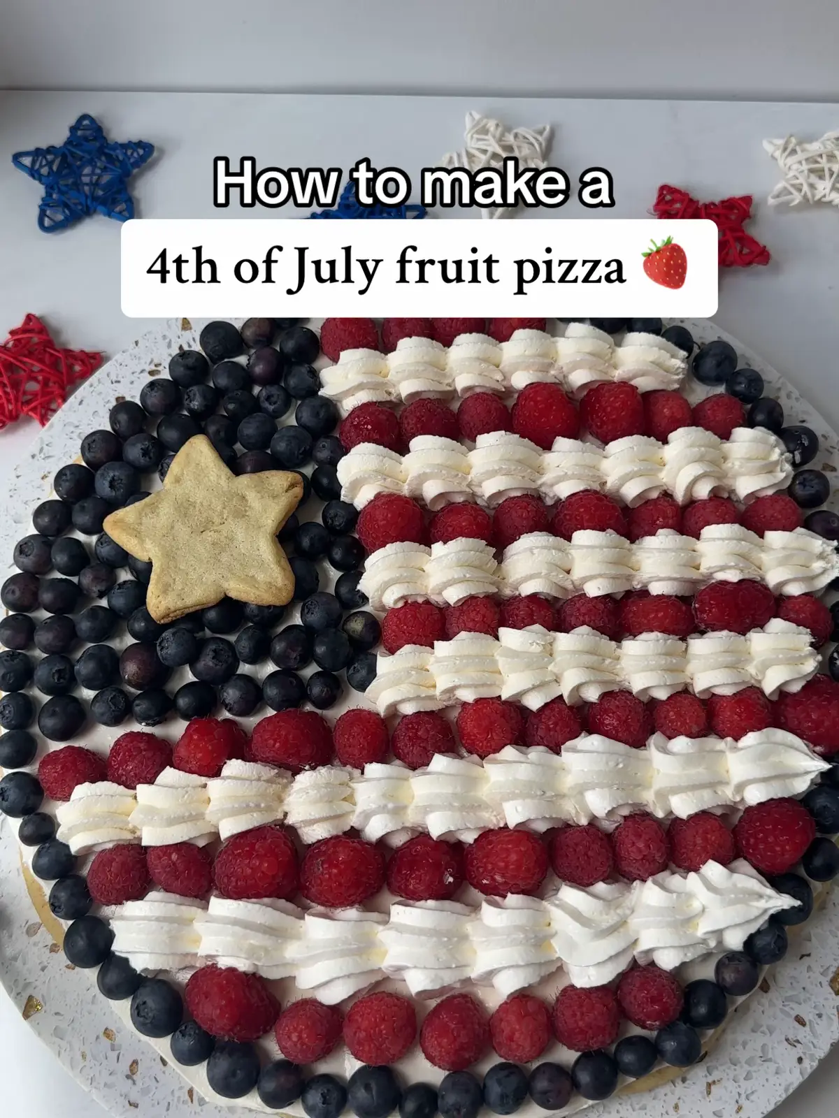 Make a showstopper dessert this 4th of July with this Fruit Flag Pizza!🫐🇺🇸 A sugar cookie crust gets topped with whipped cream cheese and adorned with fresh berries for the ultimate festive dessert!😍 #recipes #4thofjuly #dessert #fruitpizza  -1 roll of sugar cookie dough -8 oz. cream cheese -2/3 cup sugar -1 tsp. vanilla -8 oz. whipped topping -fresh blueberries & raspberries for topping