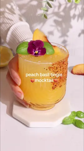 My viral Peach Basil Tingle mocktail 🍑 With peach, basil, honey, lemon and bubbly kombucha, this easy recipe has the goodness of vitamin C plus nourishing probiotics.  Don’t forget to save this one! Ingredients  2 oz/60ml peach puree* 1 oz/30ml lemon juice 6-8 basil leaves 1/2 teaspoon honey Top with ginger kombucha or soda Tajin for rim Pour peach puree and lemon juice into your shaker. Add  your basil and muddle gently. Place the honey in a small dish with 1/2 teaspoon honey. Microwave briefly - 5 seconds max! Mix with a spoon to create a quick honey syrup. Add the syrup to the shaker with some ice, replace the lid and shake well. Strain over ice and top with your choice of ginger kombucha or soda. Garnish and serve.  *to make the peach purée, blend 5 tinned peach slices with 1-2 tablespoons of liquid from the tin. You could also use half a fresh peach with 1-2 tablespoons water if you wish!  #mocktails #viralrecipes #dryjuly 