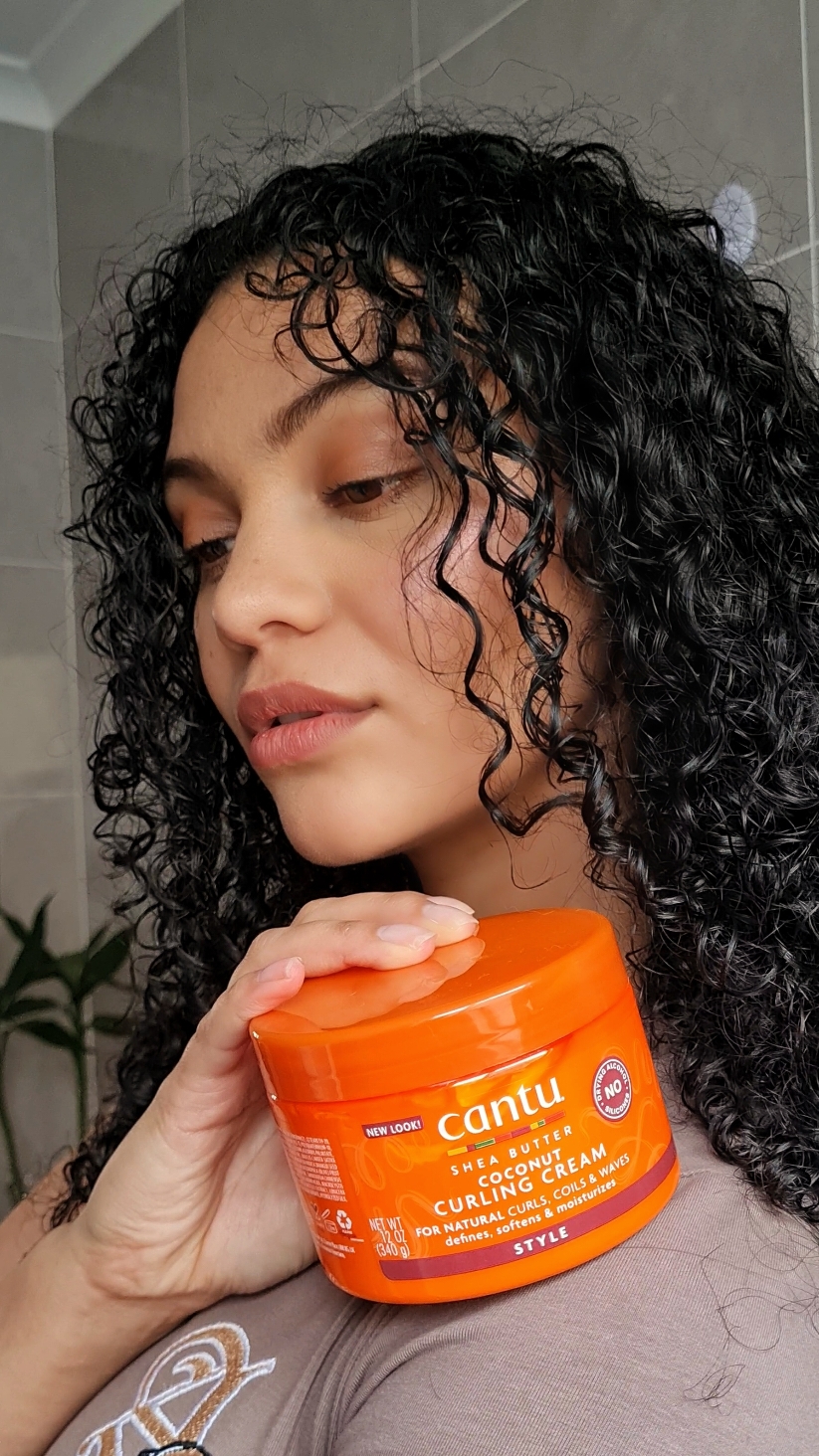 Styling my curls with @Cantu Beauty  Coconut Curling Cream 💕 Method:  Step 1: Start with damp hair - I used the cleansing cream shampoo and hydrating cream conditioner from Cantu to ensure my hair is clean.  Step 2: Scoop Out A Generous Amount Of Curl Cream - Always start with a little cream and add more if needed, this ensures that you don't use too much product as it could weigh down your curls. Step 3: Apply Curl Cream - ensure you apply the curl cream evenly by sectioning your hair or using a wide comb. I have fine hair strands, so I find it easiest to use my fingers to distribute the product.  Step 4: Scrunch Your Curls For Definition - gently scrunch your hair to enhance and define your natural curl pattern. Sometimes, I would gently shake my hair to help  separate my curls.  Step 5: Air-Dry Or Use A Diffuser To Dry Your Hair - I often use a hair diffuser on low heat as it speeds up the drying process, it also makes my curls more voluminous and bouncy. I hope this guide makes styling your curls easier. Give it a try, and stay tuned for more videos to come 💕