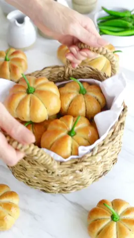 Mini Pumpkin Pizzas 🍕 Ingredients: • 3/4 cup milk • 3/4 cup water • 3/4 tbsp instant yeast • 1 tbsp sugar • 2 tbsp milk powder • 1/3 cup vegetable oil  • 2 tbsp plain yoghurt (optional) • 2 tsp salt • 3 1/2 to 4 cups all purpose flour Method  1.Combine milk and water in a pan, warm it gently. 2.In a large bowl, mix the yeast and sugar into the milk-water mixture. Cover and let it sit for 10-15 minutes until the yeast becomes puffy. 3.Add oil, yogurt, and gradually stir in 3 cups of flour along with milk powder and salt. Continue adding flour until the dough forms, up to 4 cups, but add it gradually. 4.Knead the dough on a floured surface for 5-6 minutes until it’s smooth and elastic. 5.Coat the dough with oil, let it rise until doubled in size (30-60 minutes). 6.Divide the dough into 16 pieces, flatten each into a small circle. 7.Fill with pizza sauce, pepperoni, and mozzarella cheese, then seal them into filled balls. 8.Now, flip the ball over so that the smooth side is facing up. 9.Take one of the oiled strings and slide it underneath the bun. 10.Bring the two ends of the string together and tie a twist knot on top of the bun. 11.Next, flip the bun over again, and wrap the string around it, tying another twist knot on the opposite side. 12.Continue this process until you’ve divided the bun into 8 sections, making sure not to tighten the string too much. Keep a gentle touch as you twist and turn the string around the bun. 13.Finally, flip the prepared bun one more time so that the knot is at the bottom, giving you a neat and pumpkin-shaped top. 14.Place on a greased tray, let them rise for 20 minutes, then brush with an egg wash. 15.Bake at 180°C for 15-20 minutes until golden. Carefully remove strings with small scissors to avoid tearing the buns. #fallrecipes #pumpkin #pumpkinseason