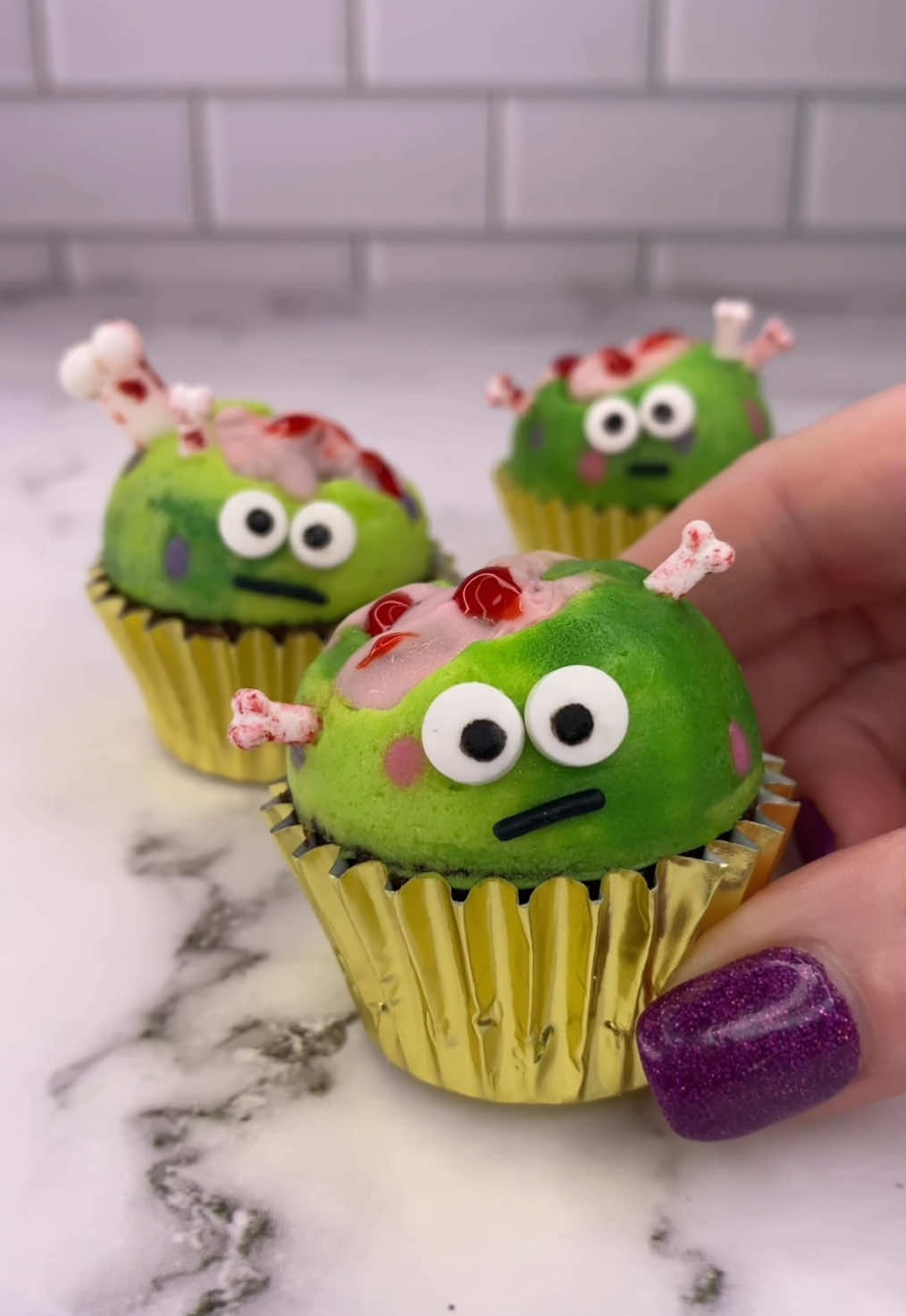 Little monsters.. big brains 🧠 💚 How cute are these little brainiacs 🧠🩷 How I made them 💁🏼‍♀️ 💚 For the brains 🧠 I dipped walnuts in pink chocolate and let them set. 💚 I added them to my silicone cake pop mold. 💚 I piped coloured buttercream dots around the sides of the mold and popped them in the freezer for 10 minutes. 💚 I then added two toned green buttercream into the mold, pressed my mini cupcakes on top and froze for further 20 minutes. 💚 I pushed them out of the mold and decorated with wiltoncakes Halloween eyes and bones, a sprinkle for the mouth 👄 and blood on the brain 🧠  #cupcake #minicake #halloweenbaking #spookyseason #bakinginspo #cakedbyrach #cupcakeart #monsters