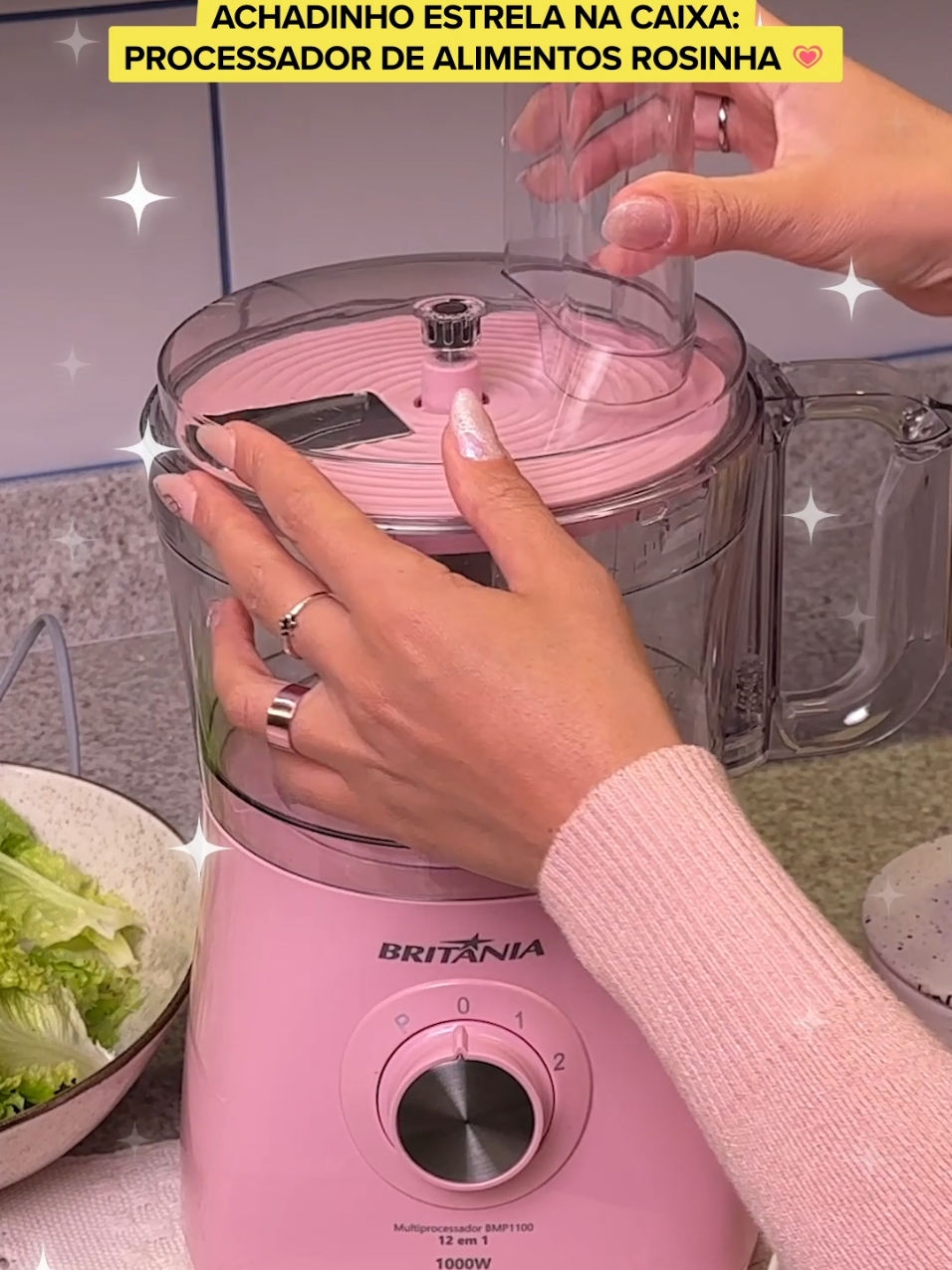 Processador de alimento é TU-DO. Mas tem que ser rosinha, né? 👉👈 Então coloquei no precinho pra você levar #AchadinhosMercadoLivre #EstrelasNaCaixa #DescriçãoDaImagem O vídeo começa com as mãos de uma pessoa segurando a base de um processador de alimentos na cor rosa. Aparece um texto que revela do que se trata: “Achadinho Estrela na Caixa: Processador de alimentos rosinha”. Enquanto o produto é montado sobre a bancada da cozinha, aparece uma animação na tela de uma caixa do Mercado Livre abrindo e saindo de dentro uma estrela, que se espalha em várias estrelas pelos cantos do vídeo e permanece até o final deste. Agora com todas as peças encaixadas, as mãos ligam o produto e colocam um pepino tipo japonês pelo vão de inserção de alimentos, ele é rapidamente fatiado, formando rodelas finas. As mãos aparecem finalizando uma tigela grande de salada de alface, tomate e com os pepinos fatiados. Agora o processador aparece com outras peças: trata-se de um espremedor de laranjas. As mãos ligam e espremem uma metade de laranja e aparecem colocando o suco em um copo ao lado da salada. O vídeo se encerra mostrando o processador, a salada e o suco e com um botão rosa escrito “Compre no app”.