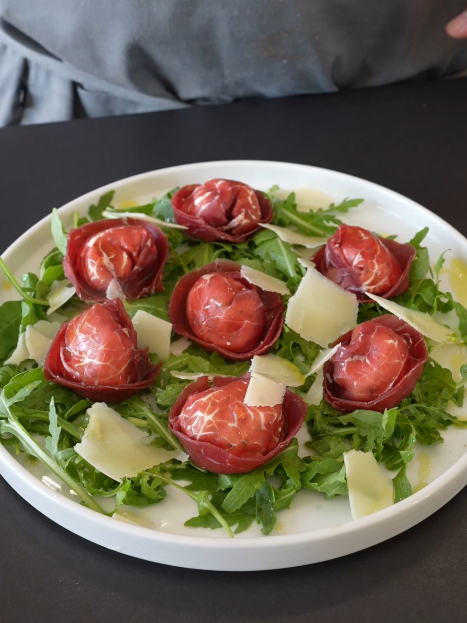 BRESAOLA TORTELLI! you haven't seen nothing like this yet! Ingredients for 7 slices of bresaola: 7 slices of bresaola 1/2 cup goat ricotta (100 g) 2 tablespoons grated Parmesan (20 g) 1 tablespoon toasted pine nuts (10 g) 1 tablespoon chopped parsley Salt and pepper to taste Arugula to taste Instructions: Mix the ricotta with the Parmesan, pine nuts, parsley, salt, and pepper. Fill each slice of bresaola with the mixture and fold it into a tortello. Serve the bresaola tortelli on a bed of arugula.