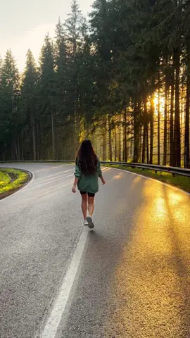 She runs freely down an empty road, the golden hour casting its warm glow through the trees, draping her in light and shadows. The sun dips lower, turning everything it touches into soft amber and gold, as if time itself has paused to hold this moment a little longer. There’s a quiet magic in the air, a sense that something beautiful and fleeting is unfolding, and all you can do is watch, captivated. 🌅✨ #GoldenHour #MomentsLikeThese #Nature’sMagic #fyp #naturevibes #fy #travel #creator #slowliving #moody #forest #mountain 