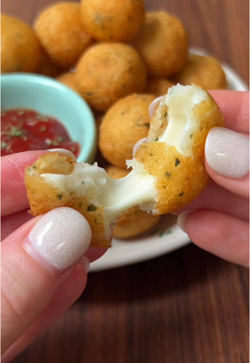 Cheesy Garlic Potato Bites 🥔✨ Ingredients: 2 potatoes  2 tbs butter 1/3 cup Parmesan cheese 3/4 tsp salt 1/2 tsp garlic powder   1 tsp parsley 2 tbs cornstarch  1 egg Mozzarella cheese, cubed  Oil for frying  Directions: 1. Peel and slice potatoes. Boil until tender (until a fork can easily pierce the surface) 2. Mash the potatoes and butter until smooth. 3. Add Parmesan, salt, garlic powder, parsley, corn starch, and egg to mashed potatoes and mix until combined. 4. Add a cheese cube to a small portion of potato mix and roll into a ball 5. Deep fry in 350° oil until golden and crispy.