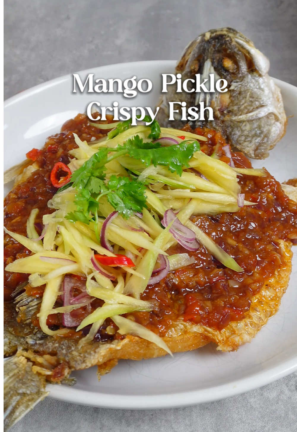 In my last reel, I picked up this locally sourced seabass from FairPrice, and today, I’m turning it into a crispy, golden masterpiece with a tangy mango salad and spicy chili paste. Chili Paste •	6 cloves garlic •	1 bird's eye chili •	5 shallots •	1 tbsp oyster sauce •	1 tbsp chili sauce •	Water, as needed Mango Pickle •	1 green mango •	1 ½ tbsp sugar •	1 tbsp fish sauce •	3 shallots, sliced •	1 calamansi, juiced •	½ lime, juiced •	1 bird's eye chili, chopped •	2 stalks coriander, chopped Crispy Fish •	1 seabass (sourced from The Fish Farm, locally produced) •	Cornstarch •	Salt Instructions 1.	First, pound the garlic, bird's eye chili, and shallots into a paste and set it aside. Firmly hold the green mango and slice it thinly. In a bowl, mix the mango strips with sugar, fish sauce, shallots, calamansi juice, lime juice, chili, and coriander. 2.	Season the seabass with salt and a light coating of cornstarch. Deep fry in hot oil until the crust turns golden, letting it sit on one side to form a crust before flipping. Local produce, like this seabass goes from farm to store in 24 hours. They are fresher, longer-lasting, sweet, and flaky. You can spot them with a red circle tag. 3.	Drain excess oil from the pan, then sauté the chili paste until fragrant. Add oyster sauce, chili sauce, and a bit of water, stirring until well combined. Pour the chili sauce over, spoon the mango salad on top, and enjoy! Recipe inspired by @cook.n.plate Shop local produce at FairPrice for extra freshness that lasts! 🌱 With naturally raised seafood and pesticide-free veggies hitting shelves within 24 hours, enjoy peak flavor that stays vibrant longer at home. Look for the red circle logo and savor quality that keeps! #SupportLocal #FreshnessThatLasts #FairPrice #FairPriceSupportsLocal @FairPrice SG 