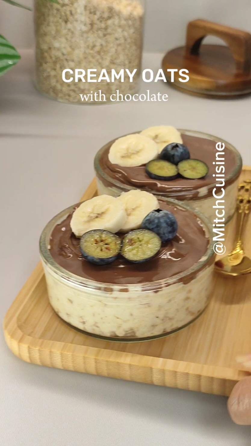 Creamy oats with melted chocolate Ingredients: 1/2 cup oats 1 mash banana 1-2 Tablespoon melted peanut butter 120 g Greek yogurt / unflavor yogurt 1-2 Tablespoon hazelnut nougat cream or any melted chocolate favorite fruits  Procedure: In a blender pour the roll oats and mix into like fine like  flour.Transfer in a large bowl and add 1 mash banana follow the melted peanut butter and yogurt add 1-2 Tablespoon of yogurt if too thick for you.Give a good mix until all combine.  Transfer in a  serving glass and top with melted chocolate and with your favorite fruits. Enjoy✨ #creamyoats #oatsrecipe #haferflocken #oats #snacks #breakfastrecipes #oatstiktok #healthydessert 