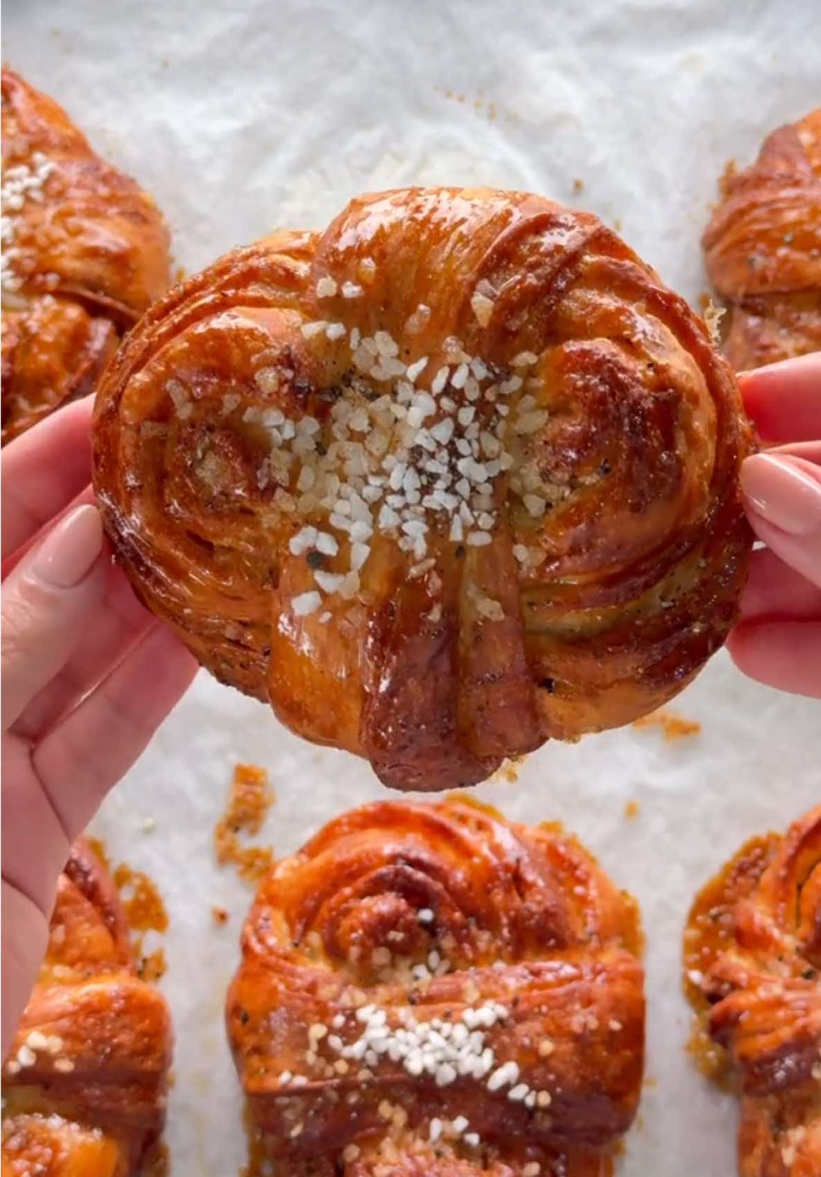 Cardamom Buns 🇸🇪🤍🧸  لفائف الهيل السويدية مقادير العجينة: 500ج طحين، (متعدد الاستخدامات) 50ج سكر 5ج ملح 7ج خميرة فورية  10ج بذور الهيل مطحونة ( نستخدم البذور الموجودة داخل الهيل ونستبعد قشرة الهيل لانها تسبب مرارة) 2بيض كبير 275مل حليب  50ج زبدة (في حرارة الغرفه) ريمونس الهيل: 100ج زبدة طرية بحرارة الغرفة 150ج سكر بني خام  20ج بذور الهيل مطحونة للتحضير: تخلط جميع المكونات حتى تصبح كريمية. تحضير العجينة: في وعاء العجانة نضيف الدقيق، السكر، الملح، الخميرة والهيل ونخلطهم، ثم نضيف البيض، الحليب، والزبدة الطرية.  هنا تكنيك العجن المهم: نعجنهم على سرعه منخفضة لحد ما تمتزج المكونات ويختفي الدقيق ثم نقفل ونغطيها ونتركها 30دقيقة، بعد كذا نشغّل العجانة ونعجنها على سرعة عالية لمدة 6-7 دقائق. لحد ما بيصير عندنا عجينة مطاطية ولامعة وقويّة.  نخمرها ليلة كاملة 8-12ساعة بالثلاجة، مهم للبريوش الناجح يكون تخميره بطيء (يتخمر بالثلاجه). اليوم التالي نطلع العجينة من الثلاجه ونخرّج الهواء منها ثم نفردها وهي بارده جدًا على شكل مستطيل وندهن الريمونس ثلاثة ارباع العجين نصفطها مرتين مثل الفيديو ثم نفردها مره اخرى بسُمك 1cm وطول 35cm ثم نقطعها بعرض 1.5cm تقريبًا لكل حبة بوزن 85-90 جرام ونلفها مثل الفيديو او اي شكل تحبونه. تتخمّر لمدة ساعة ونصف الى ساعتين، وقبل نخبزها نرش عليها سكر لؤلؤي او سكر خشن.  نخبزها على حرارة 180 درجة مئوية لمدة 15 دقيقة. وبالعافية🤍