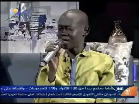 من هو شول منوت؟ شول منوت، الفنان الجنوبي صاحب الصوت العذب والإحساس المرهف، وُلد في مدينة جوبا بجنوب السودان عام 1988. بزغ نجمه عندما شارك في برنامج نجوم الغد عام 2010، حيث كان ضمن دفعة الفنانتين فهيمة عبدالله وشموس إبراهيم، وحقق المركز الثاني خلف فهيمة التي نالت المركز الأول. تميّز شول بأدائه للأغاني الوطنية والعاطفية التي لامست قلوب الجمهور. من أبرز أغانيه: أنا سوداني للفنان حسن خليفة العطبراوي، عينيا ما تبكي لكمال ترباس، لو بهمسة لمحمد وردي، وكنت فاكر لعثمان حسين. كما أبدع في أداء أغنية تعالوا شوفوا الكنت راجيه لبلال موسى، حيث تألق بشجنه وصوته العذب الذي أبكى الجمهور. ظهر شول في نجوم الغد قبل انفصال الجنوب، لكنه اختار البقاء في الخرطوم بعد الانفصال، ليواصل مسيرته الفنية بالرغم من الظروف الصعبة التي عاشها. رحلة المرض عانى شول من مرضي السل واليرقان، ما أدى إلى تدهور حالته الصحية ودخوله مستشفى أبو عنجة للأمراض الصدرية. ظل يعاني طريح الفراش لخمس سنوات، حيث رافقه شقيقه قرنق وزوجته سناء خلال هذه الفترة. على الرغم من معاناته، لم يسلم شول من الشائعات المتكررة عن وفاته التي انتشرت على وسائل التواصل الاجتماعي قبل وفاته الحقيقية. إحدى هذه الحوادث كانت عندما غادر مستشفى سنار دون علم أسرته، ما دفع شقيقه قرنق للبحث عنه حتى وجده وأبلغه بما يُقال، ليرد شول بحسرة: 