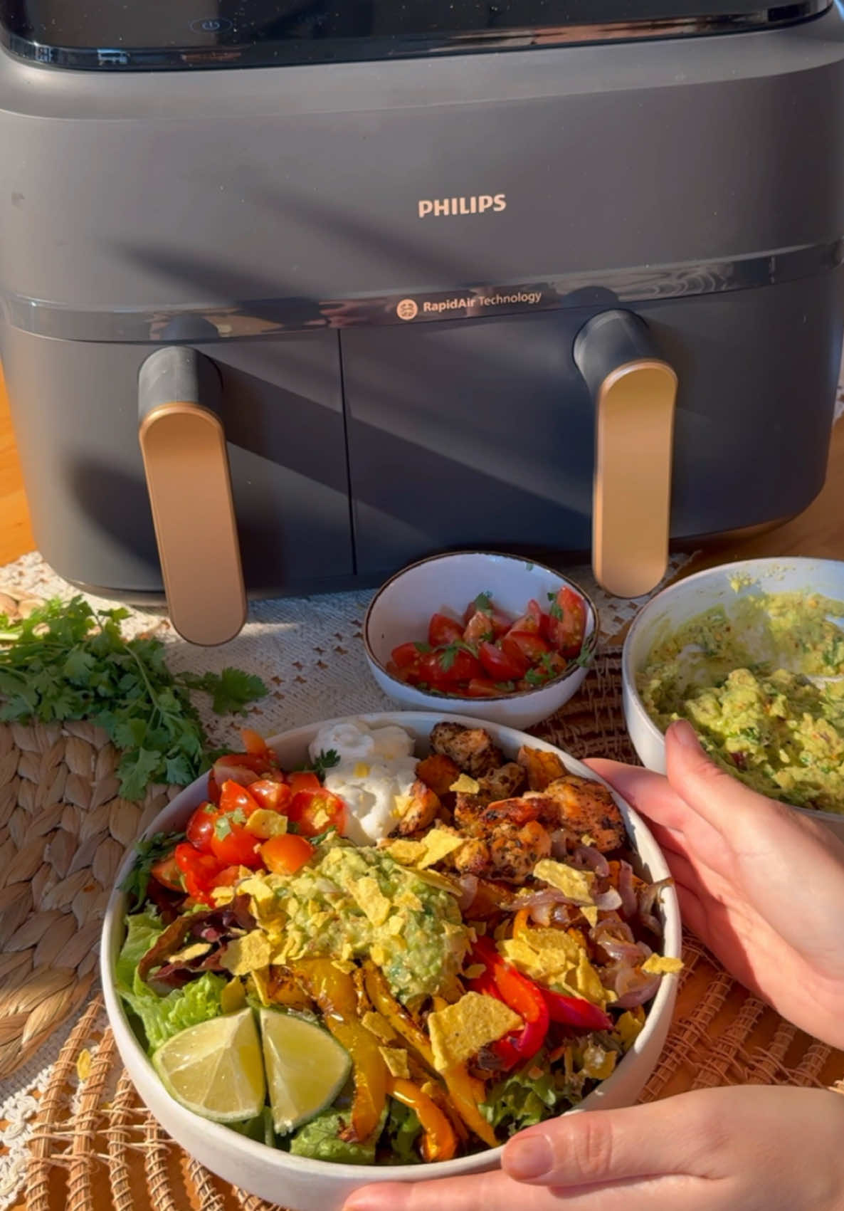 FAJITA BOWLS mit dem PHILIPS AIRFRYER 3000 SERIES DUAL BASKET 🌮 (anzeige) @Philips Home Living Germany  Kochen war noch nie so einfach und lecker. 😍 Im Philips Airfryer 3000 Dual Basket bereitest du 2 Gerichte gleichzeitig in getrennten Garkörben mit  unterschiedlicher Temperatur & Backdauer/ Garzeit zu. Diese werden super knusprig, zart und gleichmäßig gegart, dank der RapidAir Heißluft-Technologie für optimierte Wärmezirkulation. (Philips only!) Den Airfryer findet ihr hier:  https://www.philips.de/c-e/ho/kitchen/airfryer/airfryer-dualbasket.html?origin=7_700000002965871_71700000118453821_58700008738802121_43700080410782858&gclid=e78f433f736d1c405d6f247865583da8&gclsrc=3p.ds&msclkid=e78f433f736d1c405d6f247865583da8&utm_source=bing&utm_medium=cpc&utm_campaign=SEA_OMG_DE-de_BNG_PPG-DA-KA_Airfryers_BR_MIX_24FYDEDAKAPAFR_Champ&utm_term=philips%20airfryer%20dual%20basket&utm_content=DE%20-%20BR%20-%20Champ%20-%20Cat%20-%20Aifryers%20-%20Dual%20Basket Rezept für 2 Personen: 400g Hähnchenbrust 3 Paprika 1 Zwiebel 1 große Süßkartoffel 100g Tomaten 1 Avocado etwas Salat Sour Creme Koriander ggf Nachos Die Süßkartoffel in kleine Würfel schneiden. In den kleineren Garkorb geben. Mit 2 Esslöffel Olivenöl und etwas Salz bestreuen. Die Temperatur auf 180°, und die Zeit auf 30 Minuten stellen. Dann Paprika, Hähnchen und Zwiebel in Streifen schneiden und in den größeren Garkorb geben. Ebenfalls mit Öl marinieren und mit Fajitagewürz würzen. (jeweils 1 TL Paprikapulver, Chili, Salz, Pfeffer geht auch). Die Zeit auf 20 Minuten und die Temperatur auf 200° stellen. In der Zwischenzeit die Avocado klein stampfen & eine kleine geschnittene Zwiebel, eine geriebene Knoblauchzehe, etwas Koriander und Salz und Pfeffer dazu geben. Dann Tomaten in kleine Stücke schneiden & mit Koriander, Limettensaft und Salz verrühren. Nachdem die Süßkartoffel und die Paprika-Hähnchenmischung fertig gegart ist, auf einem Teller mit frischem Salat, Sour Cream, der selbst gemachten Guacamole und Tomaten Salsa sowie klein gebröselten Nachos servieren. #burritobowl #nachbowl #philipsairfryer #einfachesgericht