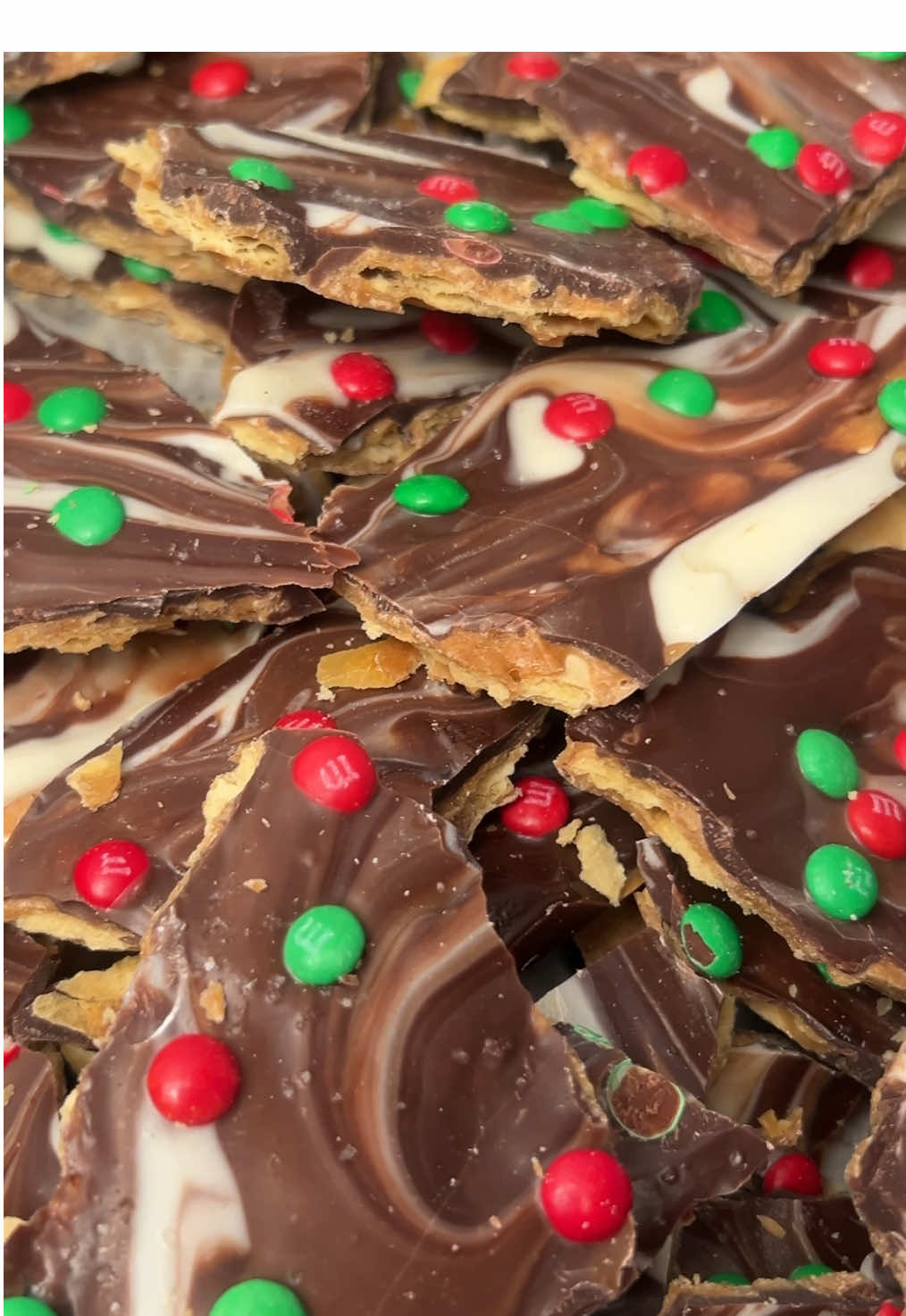 Viral Christmas Crack 😍 (Christmas Crack Cookies coming soon 🥰) #christmascrack #christmas2024 #christmasdessert #viral #holidaydesserts #fyp  Recipe: (I made 2 servings but feel free to cut this recipe in half if you want to! I don’t think that is wise, though 😭😂) 40 saltine crackers  1 cup unsalted butter  1 cup light brown sugar, packed 6 oz semi sweet chocolate  6 oz white chocolate  Sea salt for sprinkling  Mini m&ms (optional) 1.) Preheat oven to 425F. Line 2 9x13 pans with parchment paper 2.) Lay saltines in an even layer in pans.  3.) Melt butter & brown sugar over medium high. Stir til mixture boils then turn the heat down to medium & lightly boil 4-5 minutes without stirring. Remove from heat and immediately pour over crackers 4.) Bake about 5 minutes in preheated oven or until just starting to bubble 5.) Remove from oven and immediately sprinkle chocolate over toffee sauce. Allow to melt then spread over toffee.  6.) Finish with sea salt and optional m&ms. Transfer to freezer until fully set. Break into pieces and enjoy!