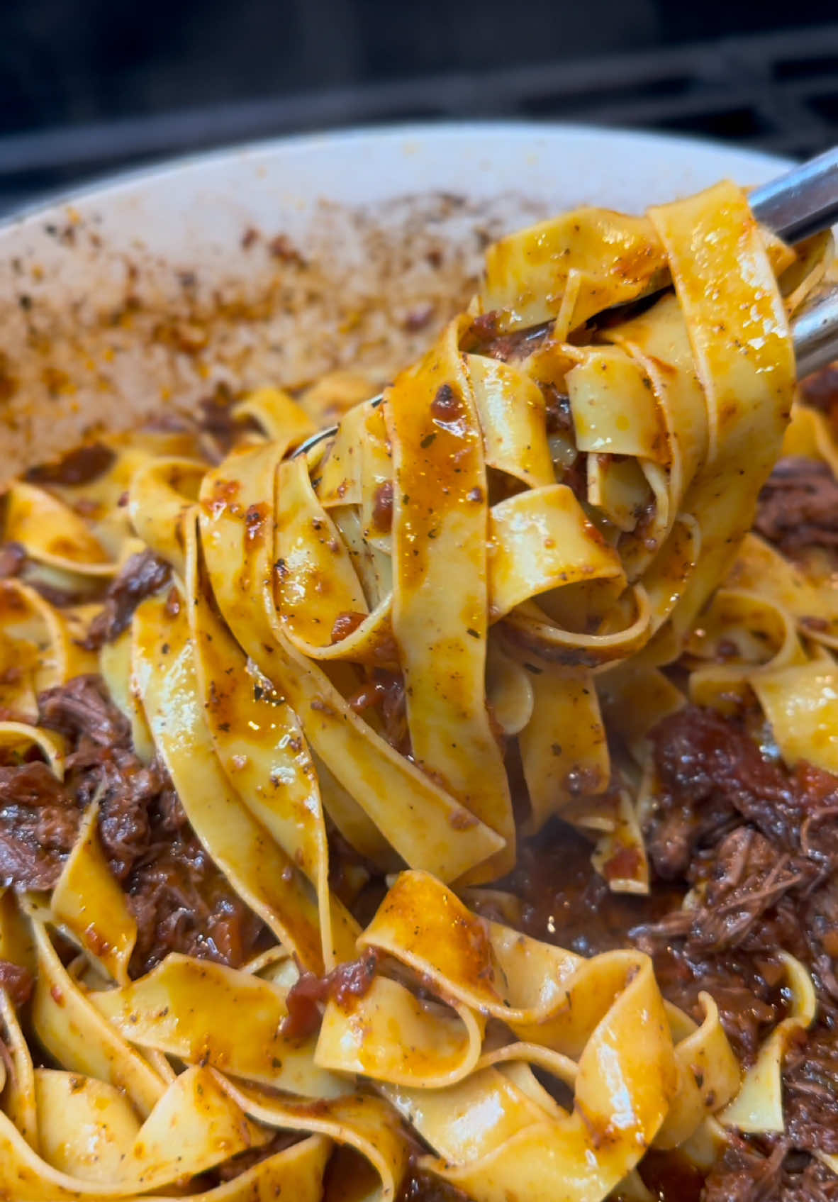 Braised to perfection and packed with flavor, this Short Rib Ragu is what cozy dreams are made of. 🍝 Perfect over pappardelle and topped with parmesan and fresh basil—it’s the ultimate comfort food. Who’s saving this recipe for their next dinner night? Ingredients: 6-8 beef short ribs (10-14 oz each) Salt and pepper,to taste 2 tbsp extra virgin olive oil 1 medium white onion,finely diced 2 carrots,finely diced 2 celery ribs,finely diced 10 garlic cloves,minced 2 1/2 cups dry red wine (e.g.,cabernet sauvignon or merlot) 32 oz beef broth 2 tsp beef bouillon paste 1 can (28 oz) peeled whole tomatoes (crush them) 2 tbsp tomato paste 1 tsp kosher salt (to taste) 1 tsp black pepper 3-4 sprigs fresh thyme 1 tsp dried basil 1 tsp dried oregano 3 bay leaves 1 parmesan cheese rind (optional) Parmesan cheese,for garnish 1 lb pappardelle pasta Fresh diced basil for garnish Method:  Season short ribs with salt and pepper. Heat olive oil in a Dutch oven over medium-high, and sear the ribs until browned on all sides. Set them aside. In the same pot, sauté onion, carrots, celery, and garlic for 3-5 minutes. Deglaze with red wine, scraping up browned bits, and cook for 3 minutes. Add beef broth, bouillon, crushed tomatoes, tomato paste, cheese rind (optional), salt, pepper, oregano, basil, bay leaves, and thyme. Place the ribs back in, bring to a boil, then simmer covered on low for 2 ½ - 3 hours. Discard bay leaves, thyme, and cheese rind. Remove ribs, shred the meat, and return it to the pot. Simmer uncovered for 30-45 minutes to thicken. For a thicker sauce, mix ½ tsp cornstarch with a little sauce, then stir it back in. Cook pasta in salted water until just shy of al dente, then toss directly into the ragu. Simmer together for 5 minutes. Serve topped with parmesan and fresh basil. #beef #shortribs #pasta #food #foodies  #instafood #cooking #Recipe #foodtiktok 