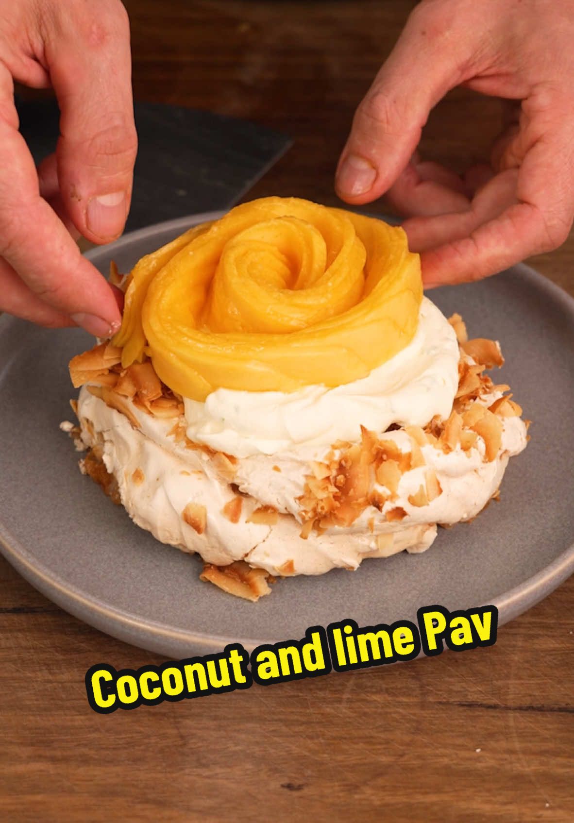 Coconut pavlova, lime cream, mango Ingredients - 7 egg whites - 300g caster sugar - 1 tsp white vinegar - 1/4 tsp vanilla paste - 2 tbsp cornflour (cornstarch) - 100g coconut flakes - 500ml whipping cream - 3 limes, zested and juiced - 3 tbsp icing sugar - 4 ripe mangoes Method 1. Add the egg whites to the bowl of a stand mixer fitted with a whisk attachment. Whisk on medium-high speed, gradually adding caster sugar. Continue mixing until the sugar is dissolved — test by rubbing the mixture between your fingers. It should feel smooth and not grainy. 2. Add vanilla paste, vinegar, and cornflour to the meringue.Whisk for another 25–30 seconds until fully combined. 3. Line a baking tray with greaseproof paper. Spoon 8 large portions of the meringue onto the paper, spacing them evenly. Use the back of a spoon to create a well in the center of each. 4. Generously sprinkle coconut flakes over the meringues. Bake in a preheated oven at 110°C for 1 hour 20 minutes, or until set but chewy in the center. 5. Turn off the oven and leave the door slightly ajar. Allow the meringues to cool completely in the oven, preferably overnight. 6. In a bowl, combine the whipping cream, lime zest, and icing sugar. Whip until soft peaks form. 7. Slice mango cheeks lengthwise. Fan out the slices and roll them into flower shapes. Drizzle the flowers with fresh lime juice. 8. Add a small dollop of cream to a plate to anchor the meringue. Place the meringue on top and add a generous spoonful of lime cream. 9. Top with a mango flower and serve. #cooking #Recipe #dessert #foryou 