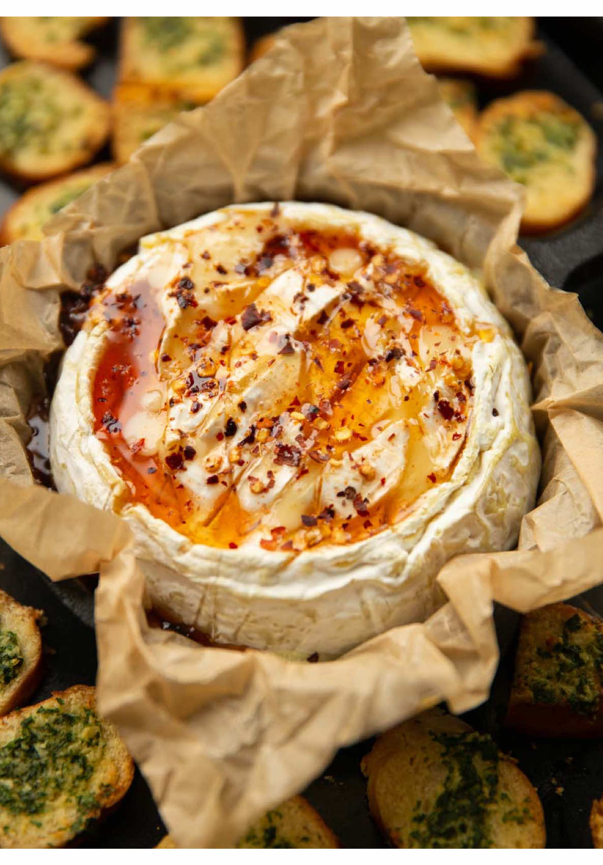 Is there anything more indulgently delicious than a whole block of baked camembert?! 😩 Enjoy!! Chris x HOT HONEY BAKED CAMEMBERT | Serves 4 INGREDIENTS ➡️Camembert: 1x 250g/9oz round block of Camembert 2 tbsp Honey 1/2 tsp Hot Sauce (I use Cholula) 1/4 tsp Chilli Flakes, or to preference ➡️Chips: 2x Bagels 3 tbsp / 45g Butter, melted 2 tsp very finely diced Fresh Parsley 1 large clove of Garlic, finely grated/diced then mashed into a paste with the side of your knife METHOD 1️⃣Preheat the oven to 180C/350F. 2️⃣Unwrap the camembert & place it in a small baking dish lined with baking paper. If you don't have a dish/oven-friendly ramekin where the camembert perfectly fits, just line the box it came in with baking paper and use that. If it didn't come in a box, make a tight parcel with aluminium foil. Anything that will catch leakage. In all cases, if one side of the camembert is more dipped than the other, place it dip-side-up (keeps the honey contained). 3️⃣In a small bowl or ramekin combine the honey, chilli flakes & hot sauce. Score the top of the camembert in a criss-cross pattern. If there is no dip in the camembert, gently press down on the top to create one. Drizzle over the honey then place in the middle of a large baking tray. 4️⃣Slice the bagels in half, then slice into chips around 1/4