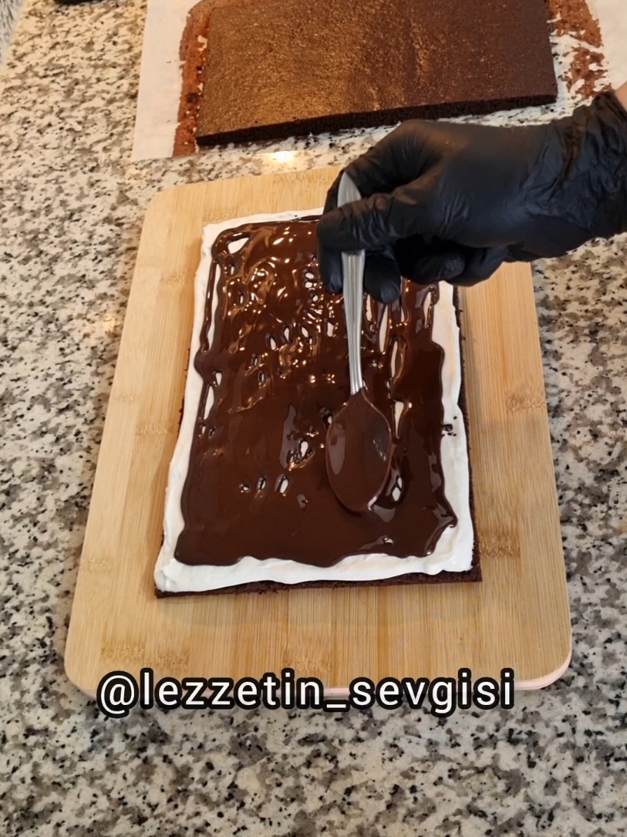 🍫Yumuşacık keki,bol kremasıyla arasındaki çikolatası ile bu lezzetli tarifi siz değerli takipçilerimle paylaşmazsan olmazdı  🍫KİNDER PİNGUİ PASTASI🍫 Keki için; 2 tane yumurta  1 tepeleme çay bardağı pudra şekeri  1 çay bardağı sıvı yağ 1 çay bardağı yoğurt  2 yemek kaşığı kakao 1 paket vanilya  Yarım paket hamur kabartma tozu  1 tepeleme çay bardağı un Kreması için; 1 paket krema(200ml) 1 poşet krem şanti  1 yemek kaşığı bal 3 veya 4 damla limon suyu Çikolatalı kaplaması ve arası için; 260g eritilmiş bitter çikolata  6 veya 7 tatlı kaşığı sıvı yağ yani çikolatanın kıvamına göre miktarı değişebiliyor  Çay bardağı 100ml  YAPILIŞI: Önce fırınımızı 180 derecede alt üst ayarda ısıtalım. Sonra bir kaba yumurtaları ve pudra şekerini koyup iyice çırpalım. Sıvı yağını ve yoğurdu ekleyip çırpalım. Sonra kuru malzemeleri ekleyip mikserimizin en düşük  derecesinde çırpalım.Sonra yağlı kağıt serili fırın tepsisine eşit bir şekilde yayalım. 30dk Önceden ısıttığımız alt üst ayarlı fırınımızın orta katına koyup 12 dakika pişirelim.12 dakikanın sonunda kekimizi fırından çıkarıp bir kenara alıp soğusun. Soğuduktan sonra kekimizi tepsiden alıp tezgahın üzerine koyup kenarlarını düzgün bir sekilde videodaki gibi hafif keselim.Sonra kekimizi ortadan ikiye kesip makas ile yağlı kağıdı keselim.Kreması için; bir kaba bütün malzemeleri koyup mikserle iyice karıştıralım.Çikolatalı kısmı için,su buharında çikolatayı eritip ocağın altını kapatıp içerisine sıvı yağ ekleyip karıştıralım.Kekin yarısını servis tahtasına ters çevirip yağlı kağıdı çıkarıp kremanın yarısını üzerine eşit bir şekilde yayıp eritilmiş çikolatatan yeteri miktarda gezdirip düzeltip derin dondurucuya koyup 15dk çikolata donana kadar bekletelim Çikolata donunca derin dondurucudan çıkarıp kremanin kalanını üzerine eşit bir şekilde yayıp kekin diğer yarısını üzerine koyup eritilmiş çikolatayı üzerine kenarlarına sürüp Üzerini kapatıp buzdolabına koyup 4 saat dinlendirelim Dinlendikten sonra kenarlarındaki akan çikolatayı kesip yağlı kağıdı alıp dilimleyip servis edebilirsiniz #kinderpingui #kinder #sütdilimi #keşfeteçık #keşfetreels #keşfetedüş #keşfeteçıkar #reelskeşfet #tiktokreels  #pasta #fyp #keşfetedüş